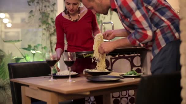 Pareja poniendo espaguetis en platos — Vídeos de Stock