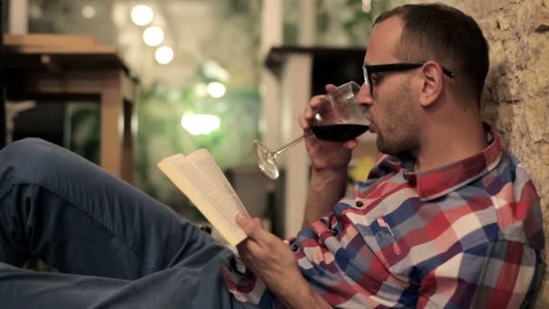 Man reading book and drinking wine — Stock Video