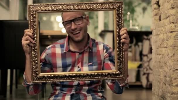 Man changing emotions behind picture frame — Stock Video