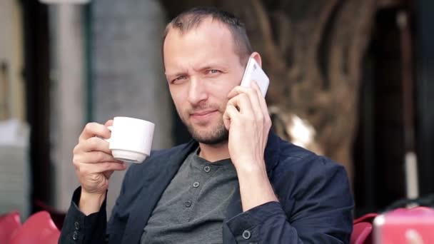 Man talking on cellphone and drinking coffee — Stock Video