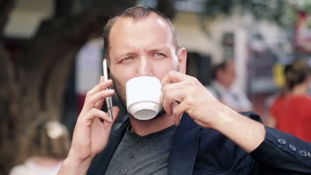 Man praten op mobiele telefoon en koffie drinken — Stockvideo