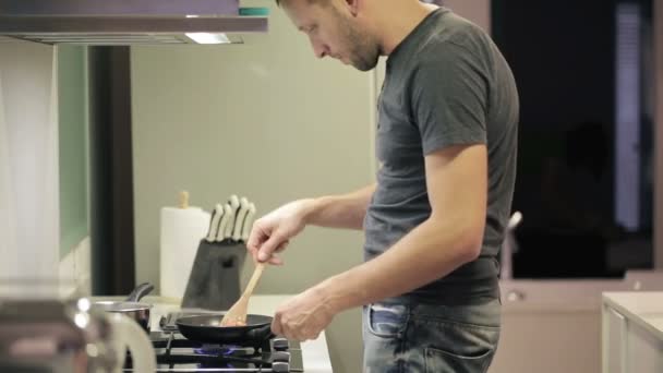 Hombre cocina en la cocina — Vídeos de Stock