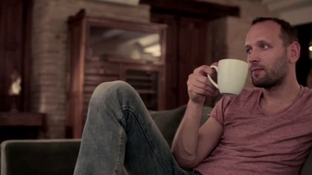 Man drinking tea on sofa — Stockvideo