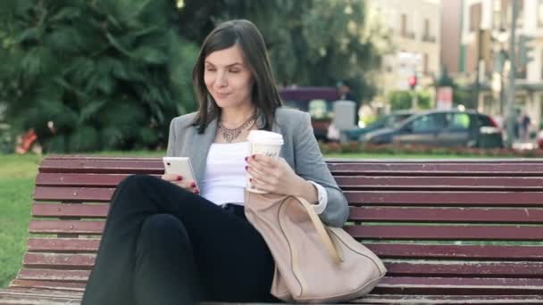 Mujer de negocios con teléfono inteligente beber café — Vídeo de stock