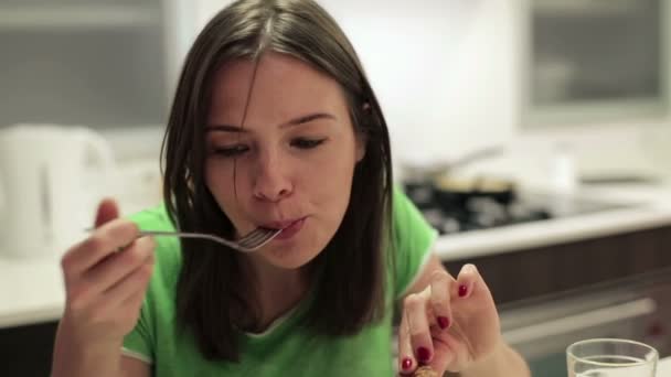 Γυναίκα τρώει το γεύμα στην κουζίνα — Αρχείο Βίντεο