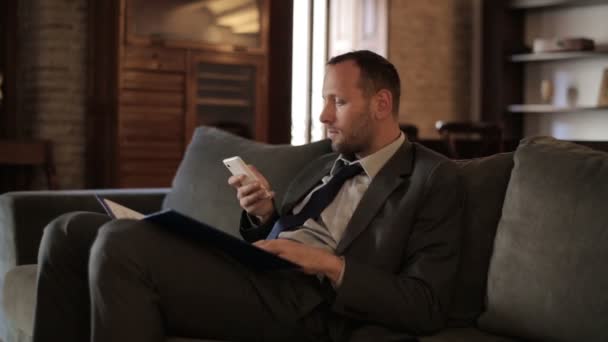 Homme d'affaires travaillant avec des documents et smartphone — Video