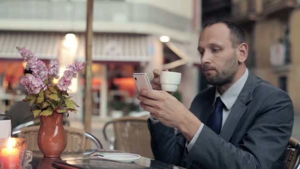 Empresário com smartphone beber café — Vídeo de Stock