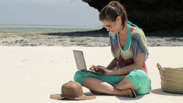 Young woman working on laptop on beautiful exotic beach — Stock Video