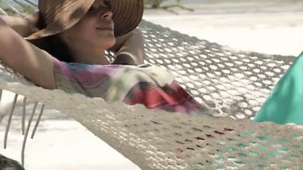 Young happy woman lying, relaxing on hammock — Stockvideo