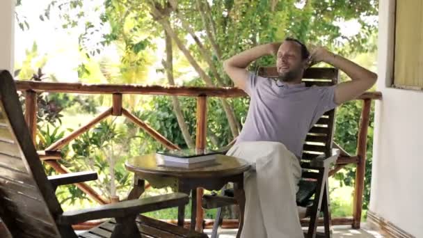 Man relaxing on country veranda — Stock Video