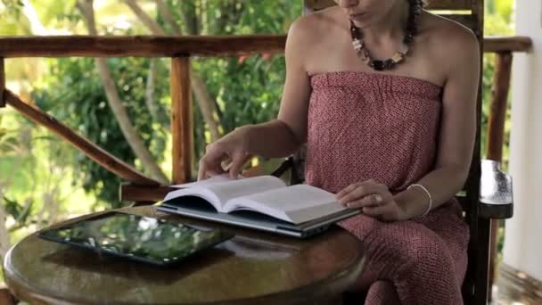 Vrouw lezing boek over veranda — Stockvideo