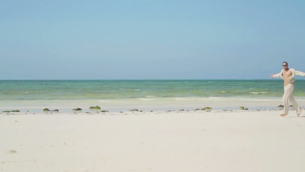 Hombre feliz corriendo en la hermosa playa exótica — Vídeos de Stock