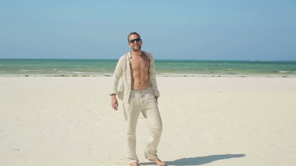 Чоловік стоїть на пляжі — стокове відео