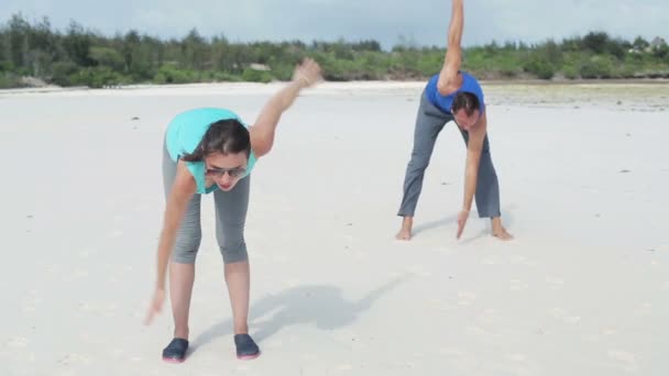 Pareja haciendo ejercicio en la playa — Vídeo de stock