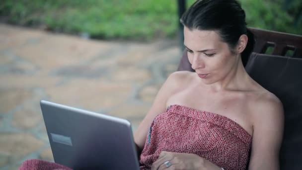 笔记本电脑在日光浴浴床上的女人 — 图库视频影像