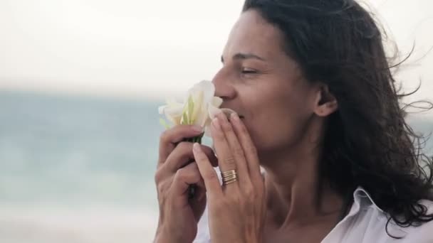 Mujer oliendo hermosas flores — Vídeo de stock