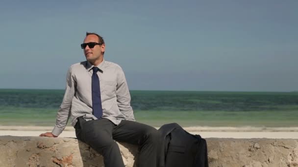 Empresário sentado na praia — Vídeo de Stock