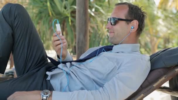 Счастливый бизнесмен слушает музыку — стоковое видео