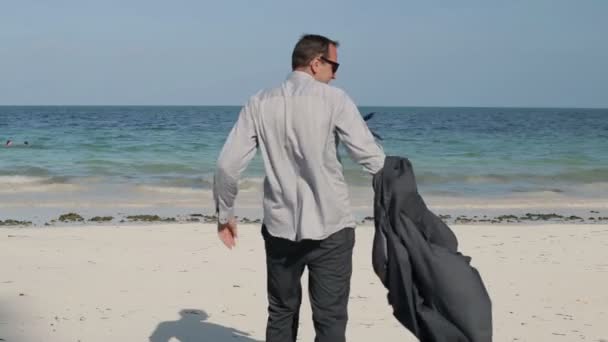 Бизнесмен раздевает красивый экзотический пляж — стоковое видео
