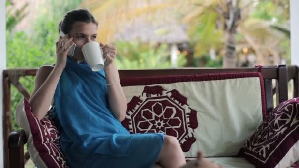 Γυναίκα μιλάει στο κινητό και πίνοντας καφέ — Αρχείο Βίντεο