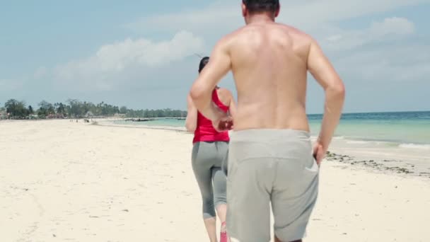 Пара пробежек по экзотическому пляжу — стоковое видео