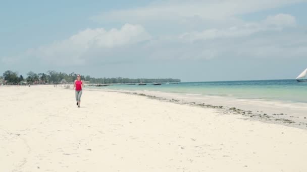 Kvinnan joggar på stranden — Stockvideo