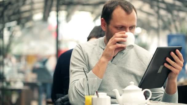 Mann mit Tablette trinkt Tee — Stockvideo