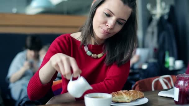 Mulher adicionando leite ao seu café — Vídeo de Stock