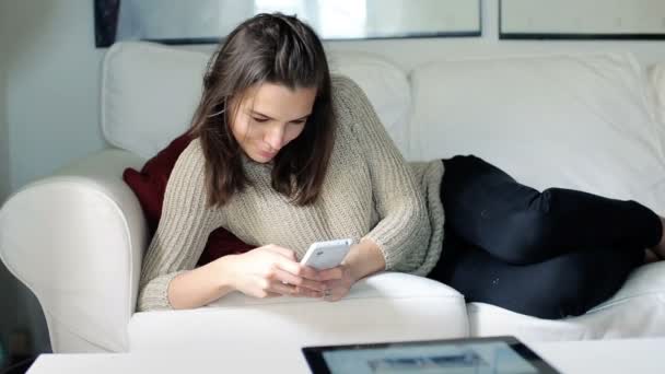 Mulher com Smartphone no sofá — Vídeo de Stock