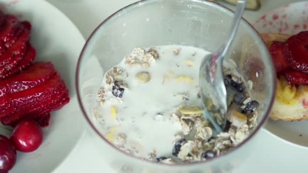 Смешивание мюсли с молоком в миске — стоковое видео