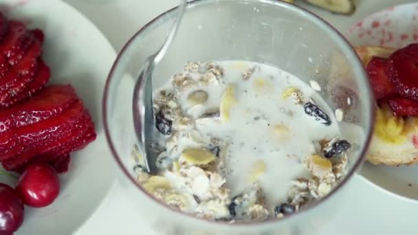 Mezclar muesli con leche en un tazón — Vídeos de Stock