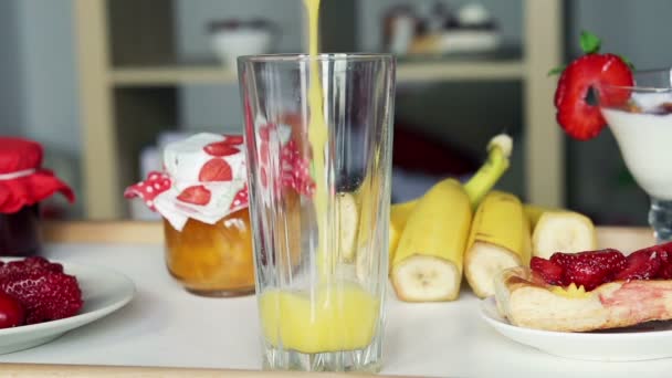 Verter jugo de naranja en un vaso — Vídeo de stock