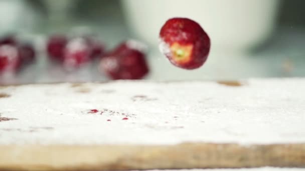 Strawberries falling on kitchen board — Stock Video