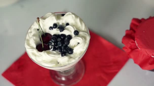 Las fresas caen en el postre de crema batida — Vídeos de Stock