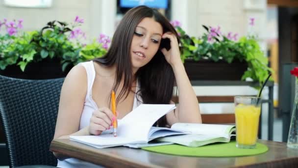 Estudiante abrumada por su tarea en la cafetería — Vídeo de stock