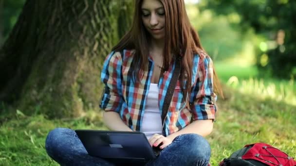 Student werkt aan laptop in park — Stockvideo