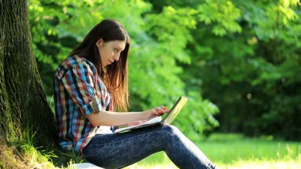 Estudiante haciendo deberes en el parque — Vídeo de stock