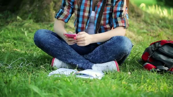 Student sms sms i parken — Stockvideo