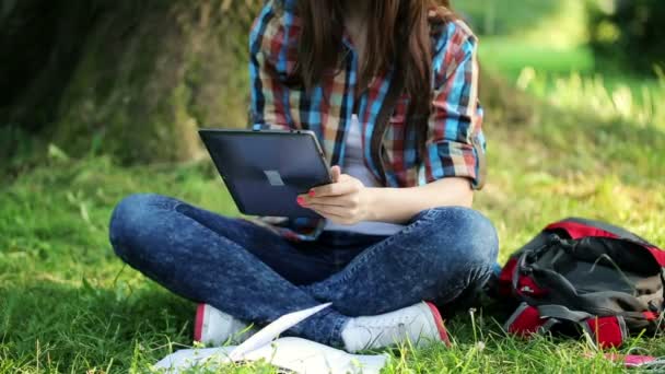 Студент с планшетным компьютером в парке — стоковое видео