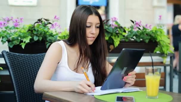 Estudiante haciendo la tarea con la ayuda de la tableta — Vídeo de stock