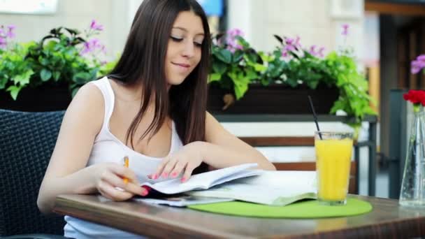 Estudiante haciendo tareas en el cuaderno en la cafetería — Vídeo de stock
