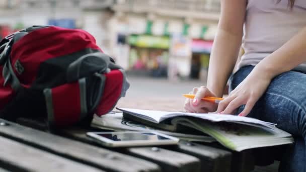 Student göra läxor i anteckningsboken i staden — Stockvideo