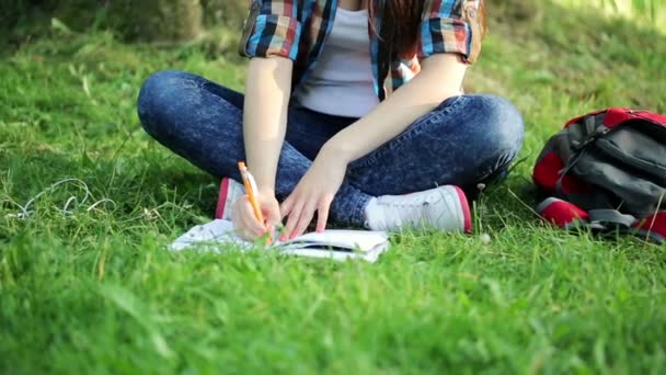 Estudiante haciendo deberes en el parque — Vídeo de stock