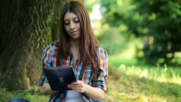 Adolescente com tablet no parque — Vídeo de Stock