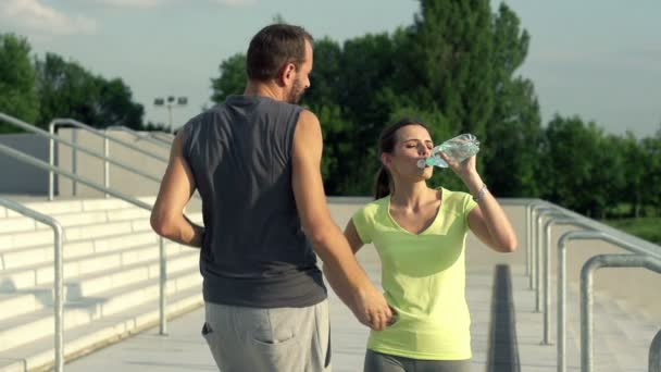 Běžci pár pitné vody po spuštění — Stock video