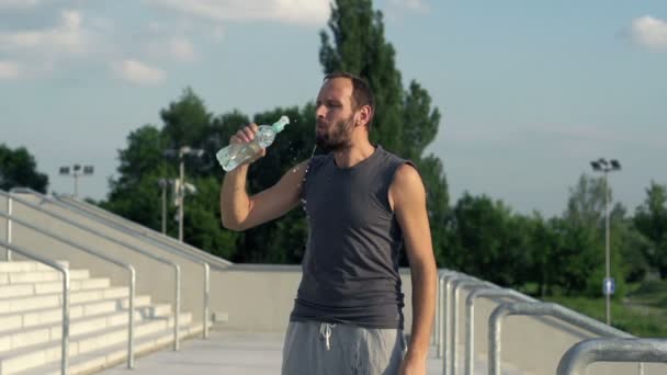 Joggerin trinkt nach Lauf Wasser — Stockvideo