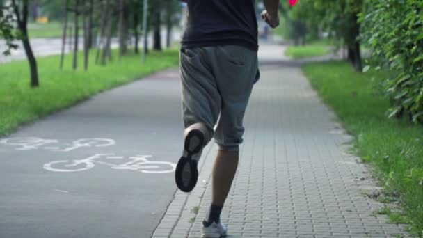 Mann joggt im Stadtpark — Stockvideo