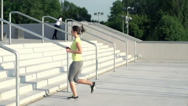 Frau joggt in der Stadt die Treppe hoch — Stockvideo