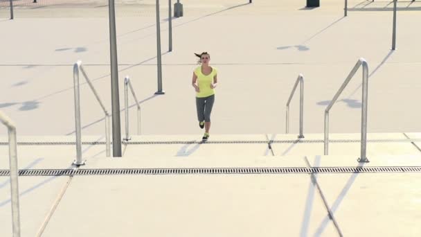 Femme jogging dans les escaliers de la ville — Video