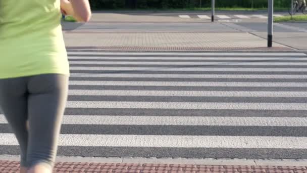 Mujer corriendo a través del cruce de cebra — Vídeos de Stock